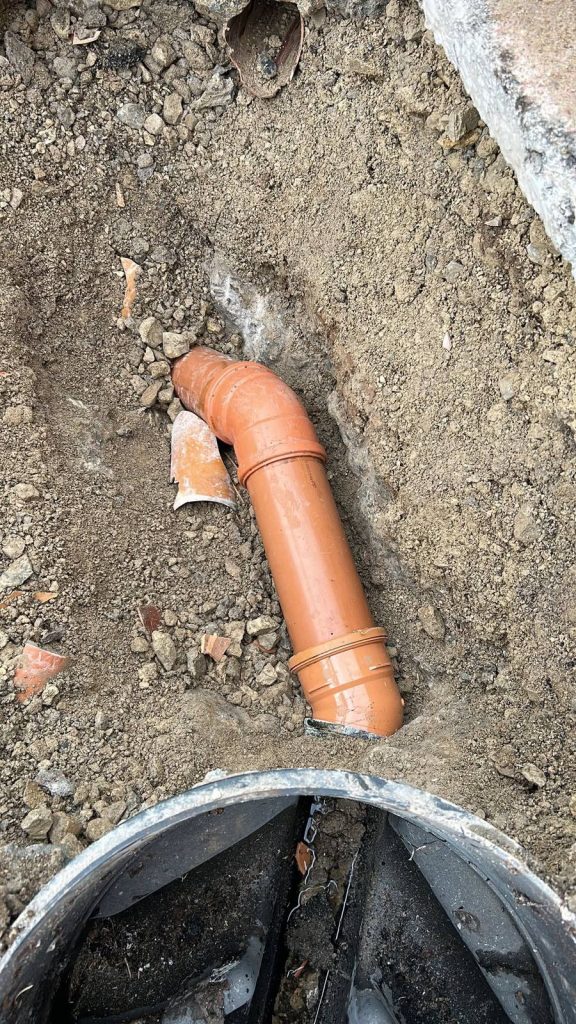 New drainage pipe and elbow joint connected above an underground chamber
