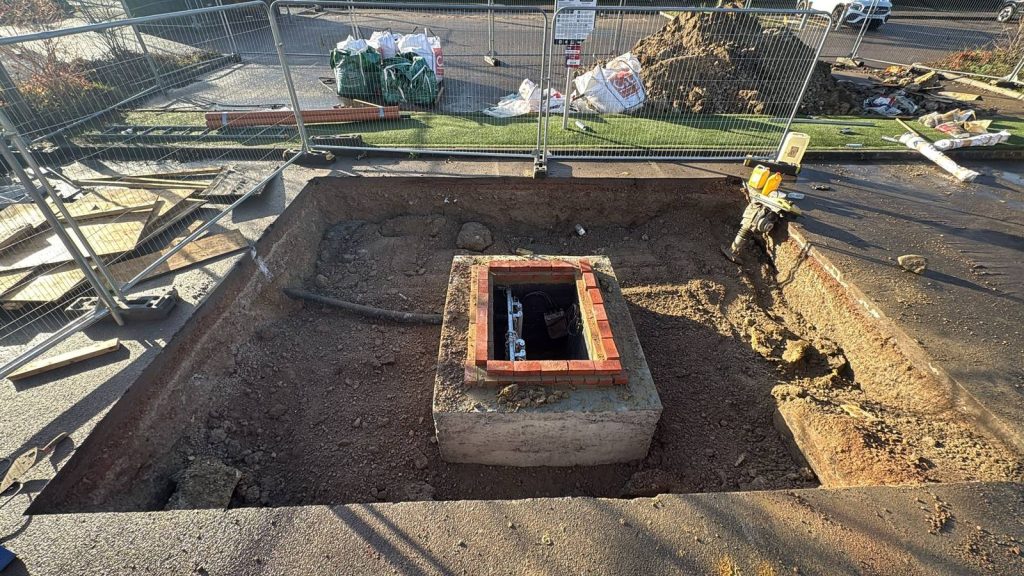 Brick-lined inspection chamber under construction on a groundworks site